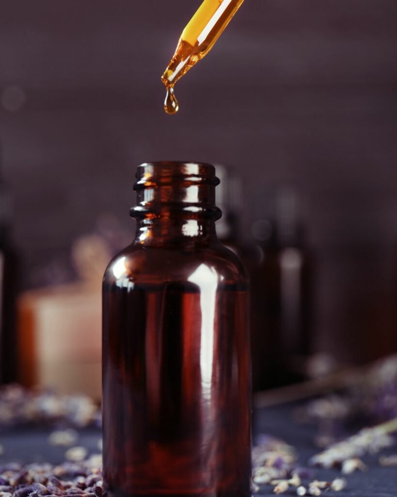 Liquid herbal extract dropping into a small brown glass bottle for health and wellness.